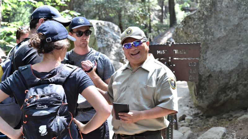 A Preventive Search and Rescue volunteer shares hiking safety tips with visitors near the start of the Mist Trail during a 2018 Yosemite Conservancy Work Week. Photo: Yosemite Conservancy/Mark Marschall 