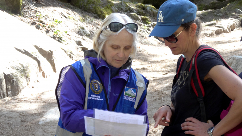 A Yosemite Conservancy volunteer shares information with a hiker during a May 2019 Preventive Search and Rescue training day near the John Muir/Mist trailhead. Photo: Yosemite Conservancy/Mark Marschall.